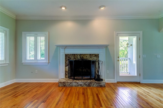 unfurnished living room with crown molding, light hardwood / wood-style flooring, and a fireplace