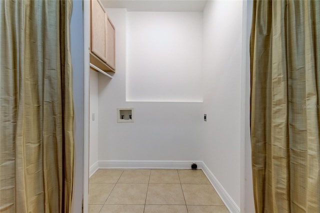 laundry room with washer hookup, cabinets, and light tile patterned floors