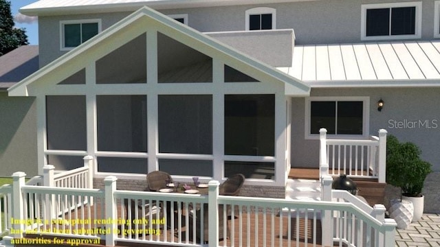 rear view of property featuring a sunroom