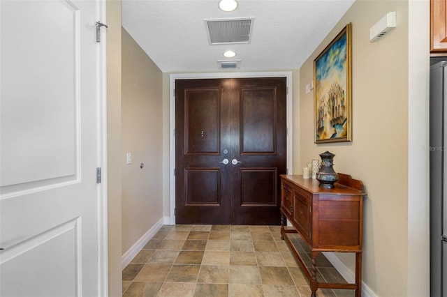 interior space with a textured ceiling and light tile floors