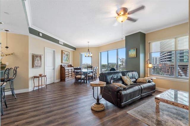 living room featuring ornamental molding, a textured ceiling, ceiling fan with notable chandelier, and dark wood-type flooring