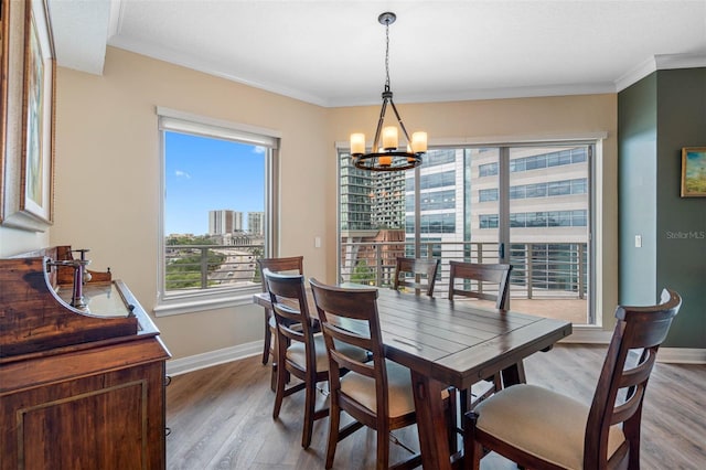 dining room featuring hardwood / wood-style floors, a chandelier, and crown molding