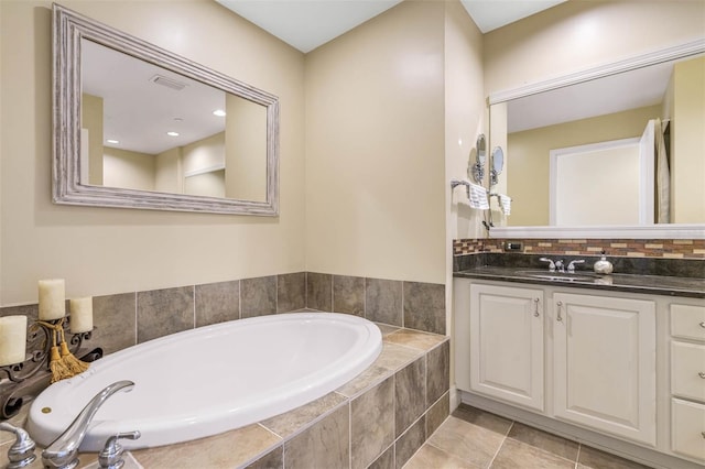 bathroom featuring vanity, a relaxing tiled bath, and tile flooring