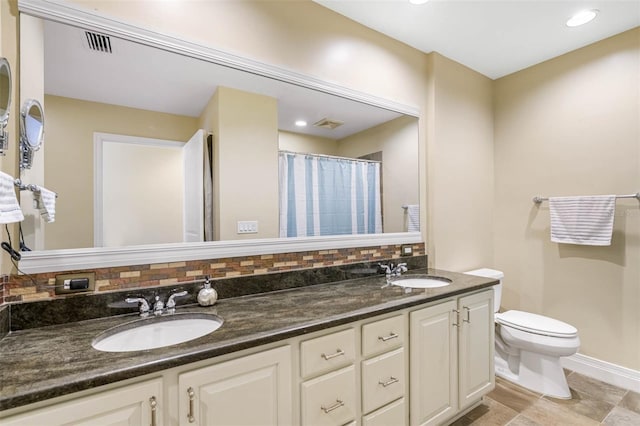 bathroom with backsplash, tile flooring, toilet, and double sink vanity