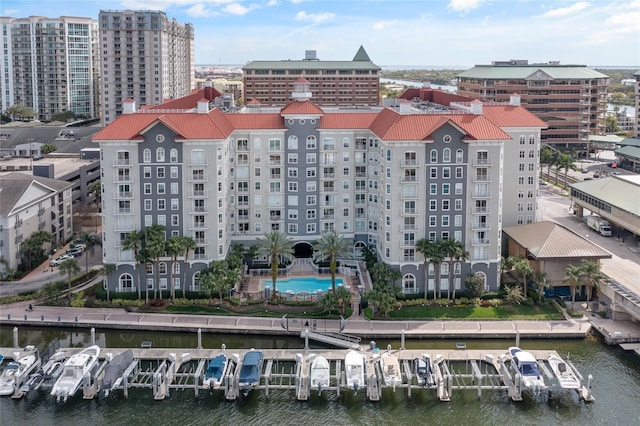 view of building exterior featuring a water view and a community pool