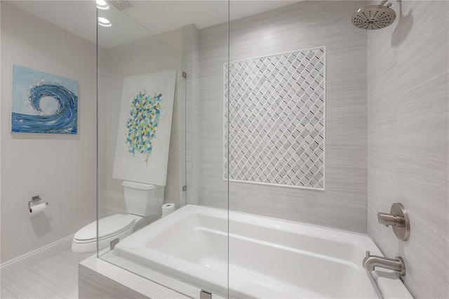 bathroom with tiled shower / bath and toilet