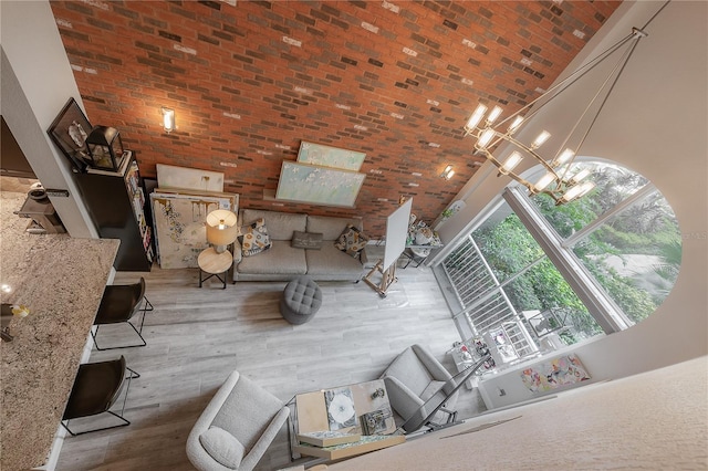 unfurnished living room with high vaulted ceiling, hardwood / wood-style flooring, and an inviting chandelier