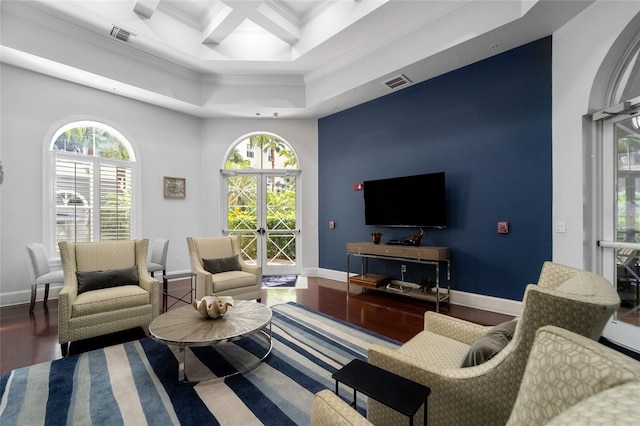 living room with french doors, a towering ceiling, coffered ceiling, hardwood / wood-style flooring, and ornamental molding