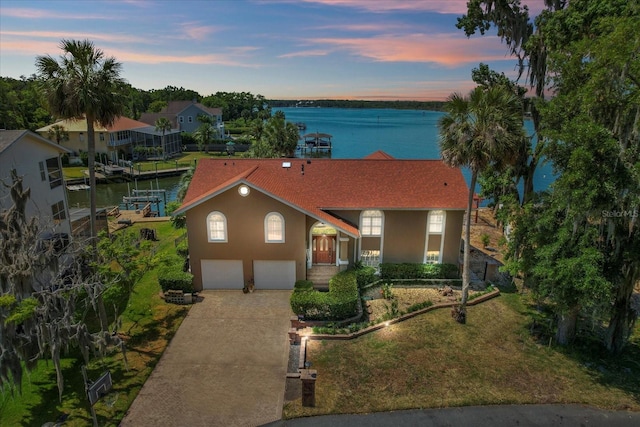 view of front of property with a garage and a water view