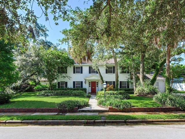 colonial inspired home with a front lawn