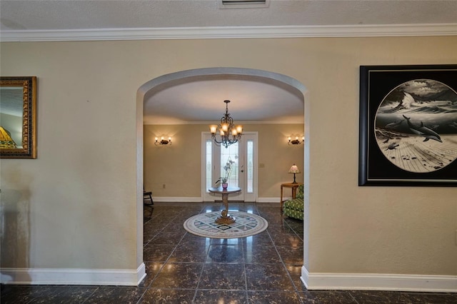 foyer entrance with a chandelier and crown molding