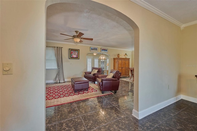 living room featuring ceiling fan, a textured ceiling, and ornamental molding