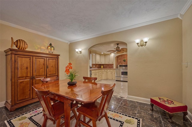 dining room featuring ceiling fan, a textured ceiling, and ornamental molding