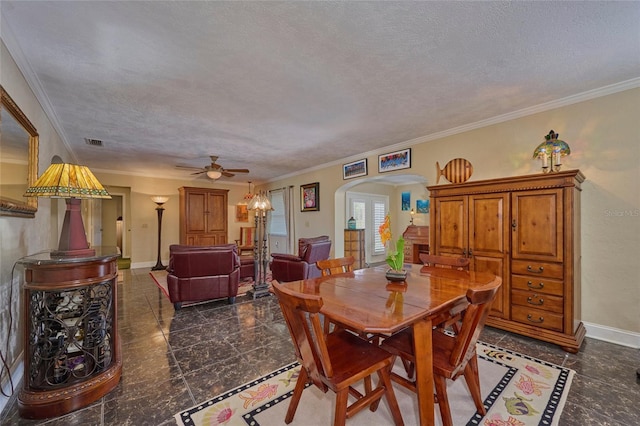 dining space with a textured ceiling, ceiling fan, and ornamental molding