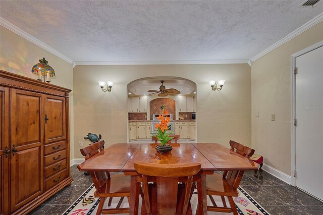 dining space with ceiling fan, a textured ceiling, and ornamental molding