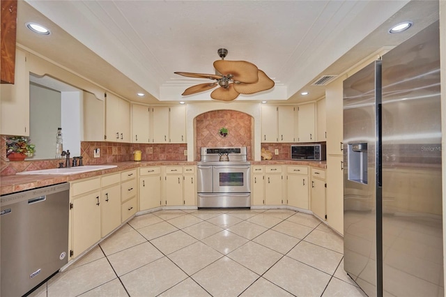 kitchen featuring ceiling fan, cream cabinets, and appliances with stainless steel finishes