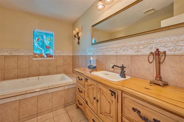 bathroom featuring tile patterned flooring, vanity, and tiled bath