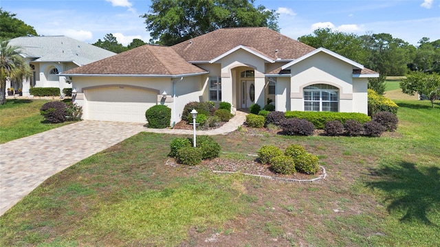 ranch-style home with a front lawn and a garage