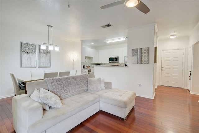 living room featuring crown molding, ceiling fan, and hardwood / wood-style floors