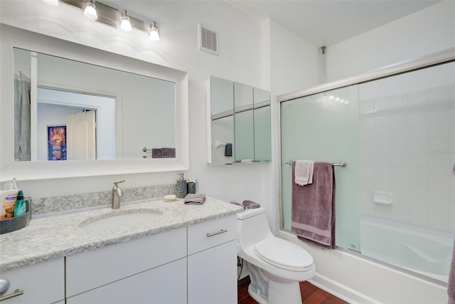 full bathroom featuring combined bath / shower with glass door, wood-type flooring, vanity, and toilet