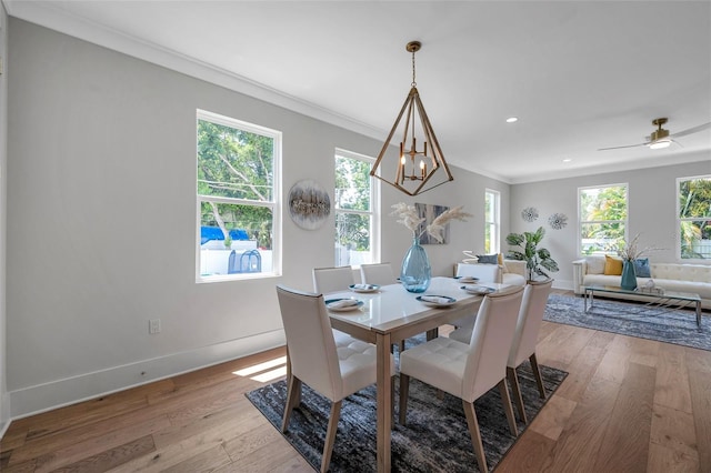 dining room with ceiling fan with notable chandelier, crown molding, and light hardwood / wood-style floors