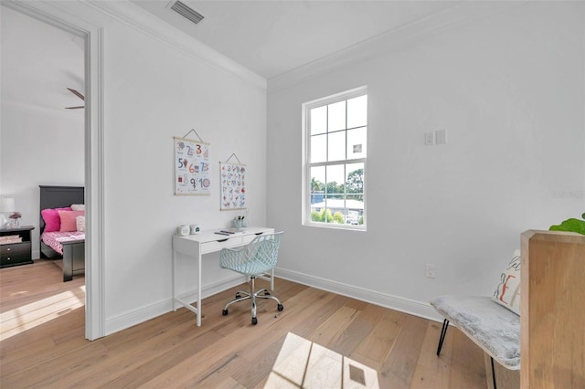 office area with light hardwood / wood-style flooring and ornamental molding