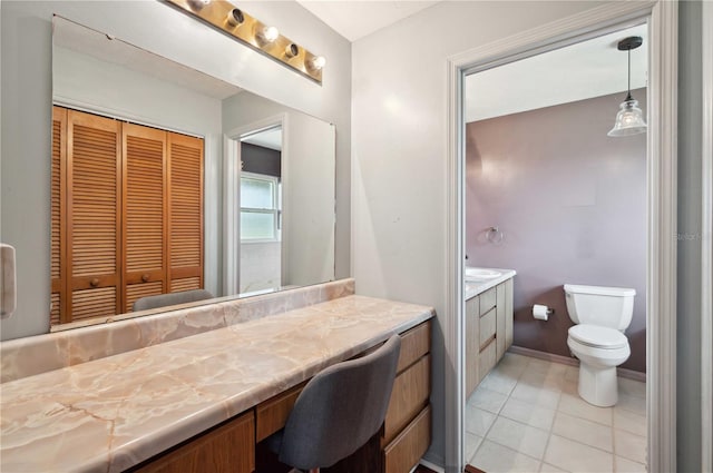 bathroom with toilet, a closet, vanity, and tile patterned floors