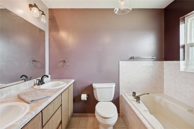 bathroom featuring toilet, vanity, tile patterned flooring, and tiled tub