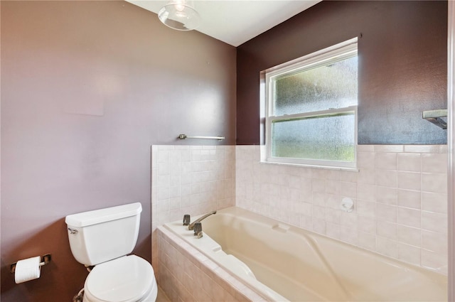 bathroom featuring toilet and tiled bath