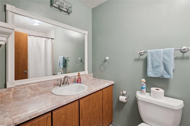 bathroom featuring toilet, vanity, and a textured ceiling