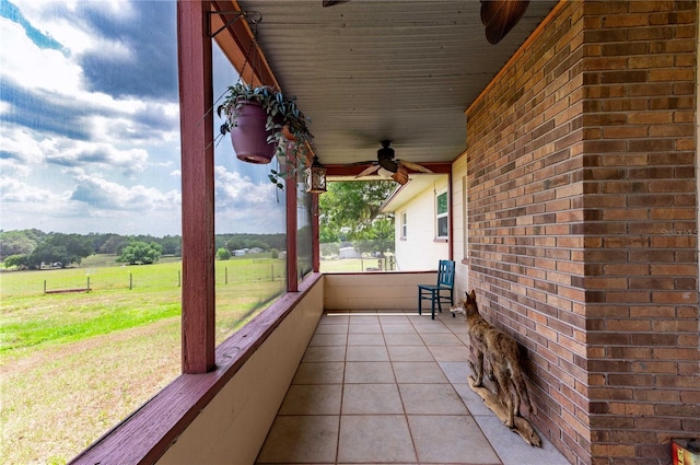 view of patio featuring ceiling fan, fence, and a rural view