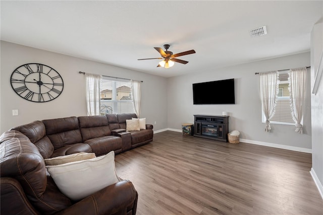 living room featuring hardwood / wood-style flooring, ceiling fan, and a fireplace