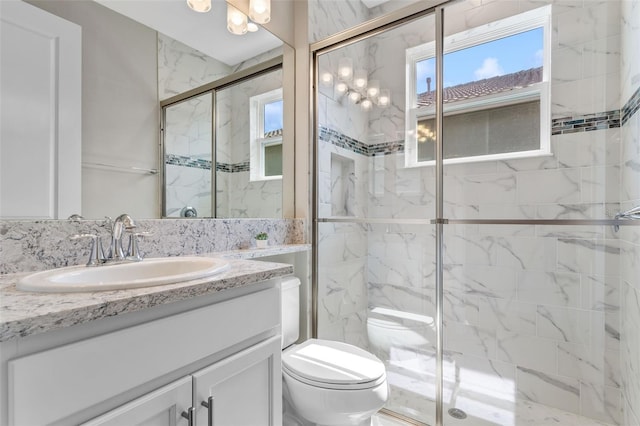 bathroom with vanity, toilet, and a shower with door