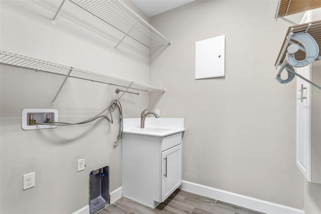 clothes washing area with washer hookup, cabinets, and sink