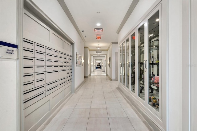 corridor with mail boxes, light tile patterned floors, and crown molding