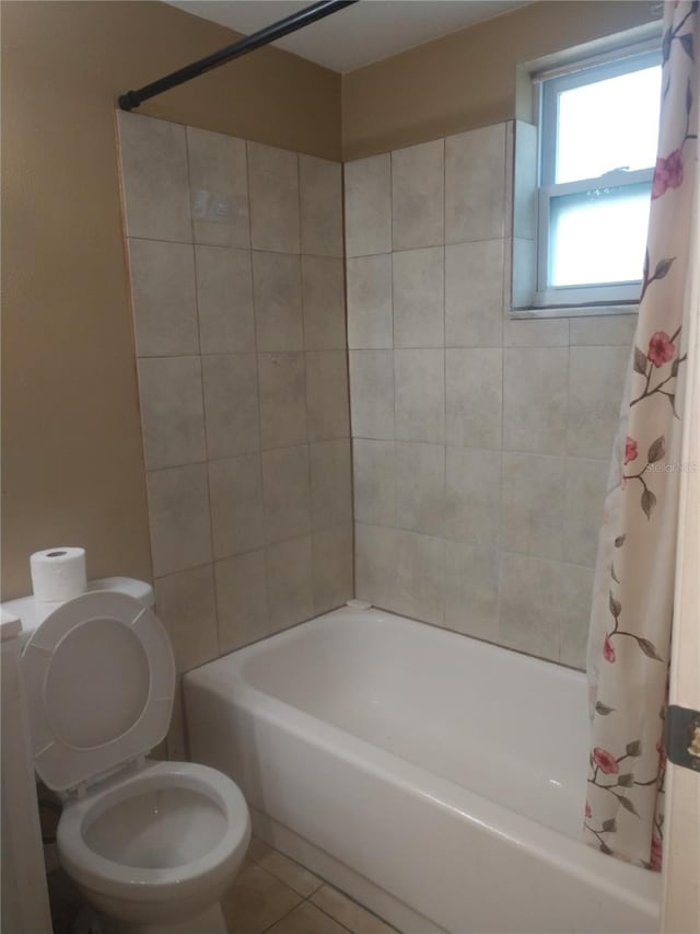 bathroom with tile flooring, shower / bath combination with curtain, and toilet