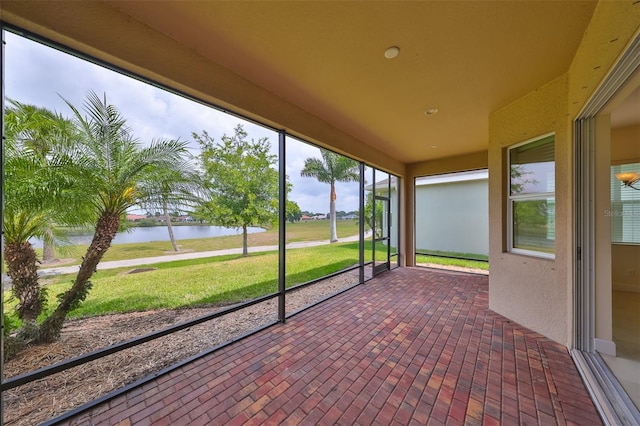 unfurnished sunroom featuring a water view