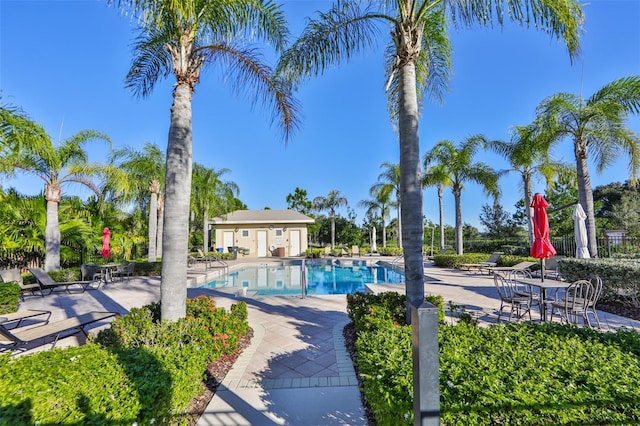 view of pool featuring a patio area and an outbuilding