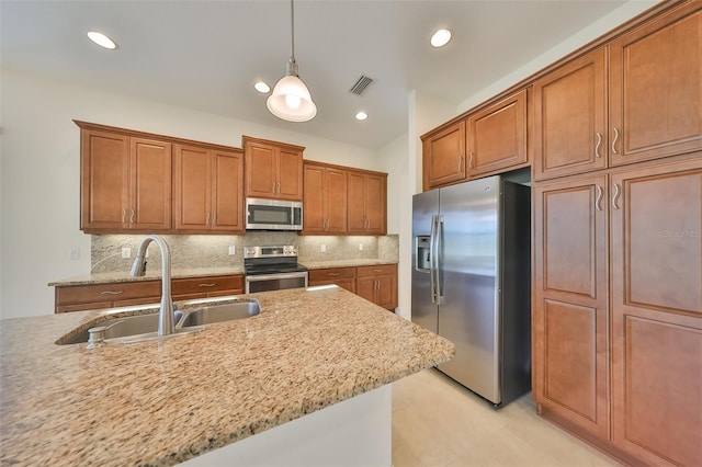 kitchen with light stone countertops, stainless steel appliances, sink, decorative light fixtures, and light tile patterned flooring