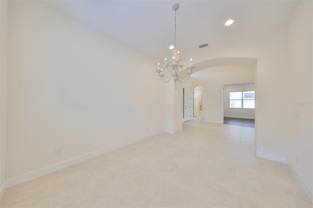 tiled empty room with lofted ceiling and an inviting chandelier