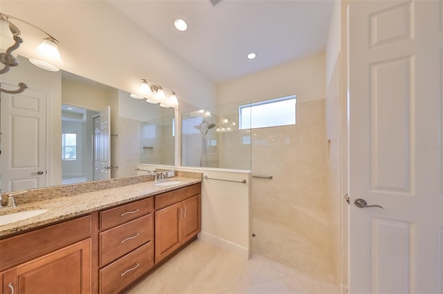 bathroom featuring tile patterned floors, vanity, and a tile shower