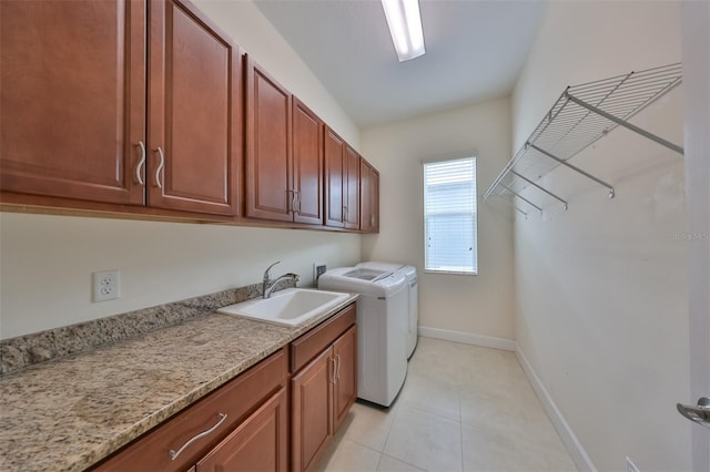 clothes washing area with cabinets, independent washer and dryer, light tile patterned flooring, and sink