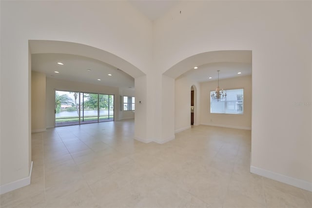 empty room with a high ceiling and a notable chandelier