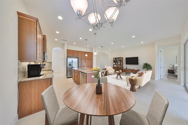 tiled dining space with sink and a chandelier