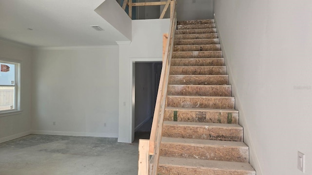 staircase featuring ornamental molding and concrete flooring