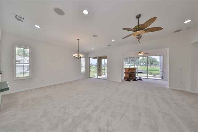 unfurnished living room with plenty of natural light, ceiling fan with notable chandelier, and light colored carpet