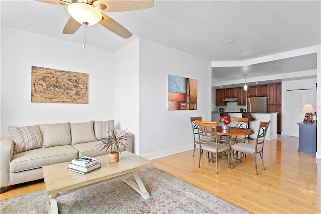 living room featuring light hardwood / wood-style floors and ceiling fan