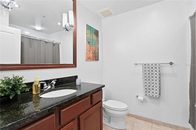 bathroom featuring tile flooring, toilet, and vanity