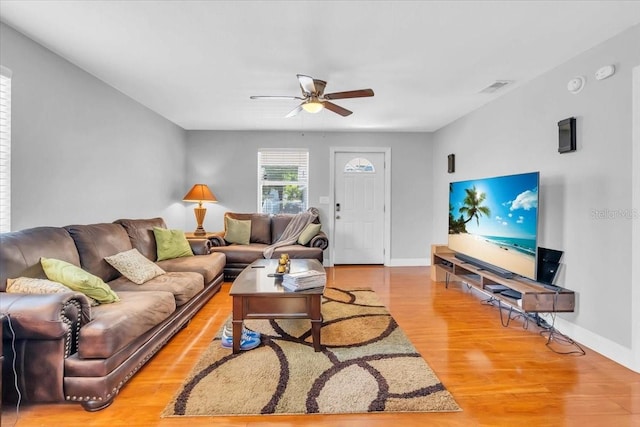 living room with light hardwood / wood-style floors and ceiling fan