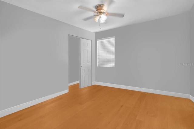 unfurnished bedroom with hardwood / wood-style floors, ceiling fan, and a closet